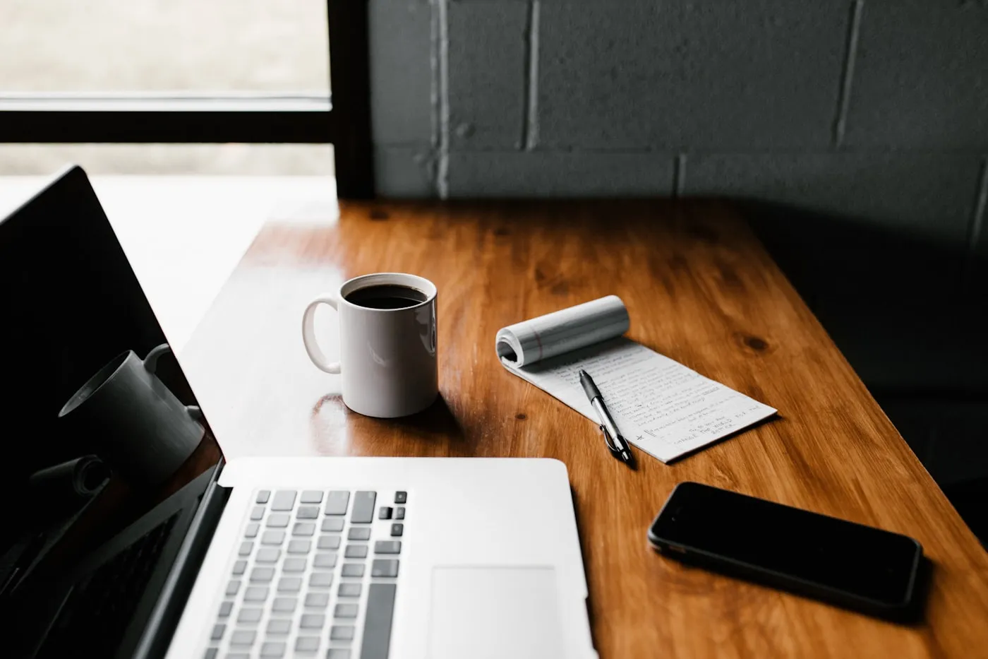 A desk with an open laptop and a cup of coffee, representing the start of a new project